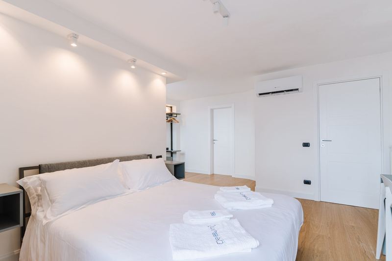 Letto matrimoniale con comodini su misura e parquet chiaro