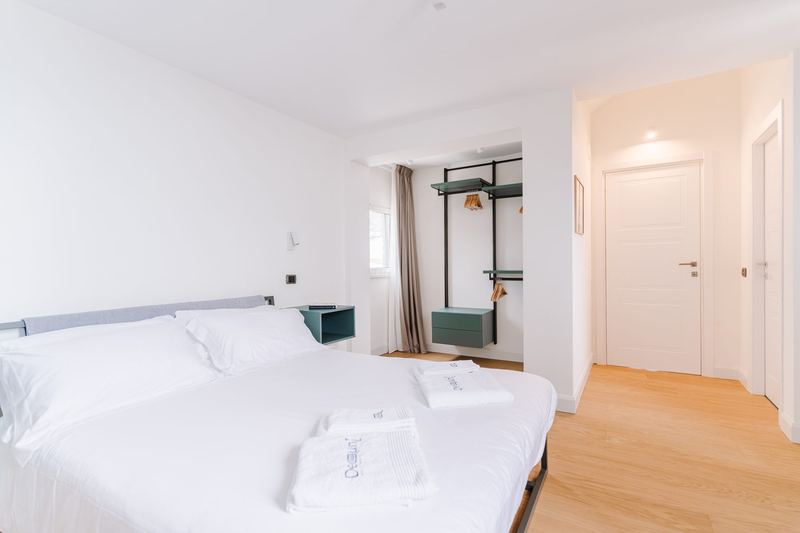 Camera con zona guardaroba aperta e accesso al bagno