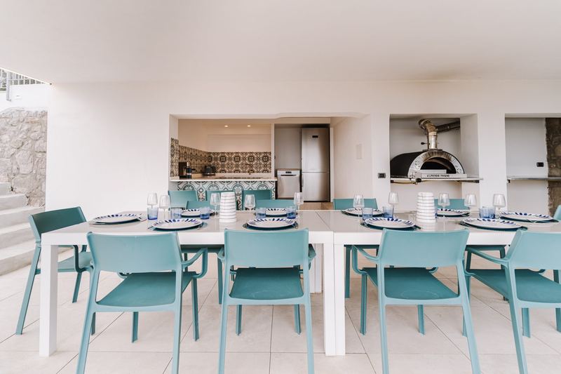 Zona pranzo esterna con forno a legna e rivestimenti in maiolica