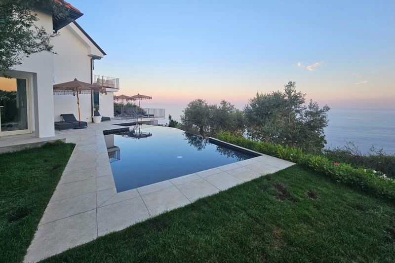 Piscina a sfioro e zona solarium al calare del sole